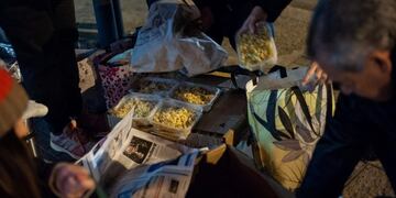 Las raciones de comida llegan en un móvil de la Guardia Urbana\u002E En la esquina de Francia y Santa Fe las reciben quienes las reparten a las personas en situación de calle\u002E (Patricio Murphy / Vía Rosario)