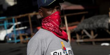 AME4002\u002E SANTO DOMINGO (REPÚBLICA DOMINICANA), 20/04/2020\u002E- Un hombre utiliza una pañoleta este lunes como tapabocas mientras camina por un mercado callejero en Santo Domingo (República Dominicana)\u002E Las autoridades dominicanas han realizado 56\u002E710 pruebas para detectar el coronavirus, entre test rápidos y PCR, registrándose hasta la fecha 4\u002E680 casos confirmados, lo que implica 354 nuevos contagios en las últimas 24 horas, informó este domingo el ministro de Salud Pública, Rafael Sánchez Cárdenas\u002E EFE/ Orlando Barría