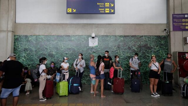 Pasajeros que buscan viajar hacia Argentina esperan embarcar sus vuelos este viernes, en el aeropuerto internacional de Río de Janeiro (Brasil) EFE/ Antonio Lacerda