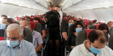 GRAF1131\u002E MADRID (ESPAÑA), 02/07/2020\u002E- Varios pasajeros se acomodan antes del despegue de un vuelo en el aeropuerto Adolfo Suárez-Barajas en Madrid, este jueves\u002E Apenas unos 20 centímetros separan a los pasajeros que viajan estos días en avión, durante jornadas de relativa tranquilidad y pocas aglomeraciones en los aeropuertos de salida y llegada\u002E EFE/Lourdes Velasco
