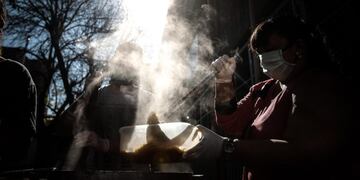 Una mujer reparte comida frente a la Parroquia Santa María Madre del Pueblo, el 19 de mayo de 2020 en Buenos Aires. EFE/ Juan Ignacio Roncoroni