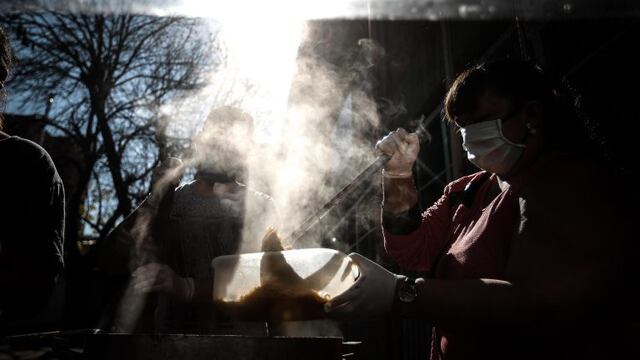 Una mujer reparte comida frente a la Parroquia Santa María Madre del Pueblo, el 19 de mayo de 2020 en Buenos Aires. EFE/ Juan Ignacio Roncoroni