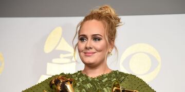 TOPSHOT - Adele poses in the press room with her trophies, including the top two Grammys of Album and Record of the Year for her blockbuster hit