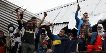 Rioting inmates stand on the rooftop of the Villa Devoto prison as they protest against authorities who they say are not doing enough to prevent the spread of the new coronavirus, in Buenos Aires, Argentina, Friday, April 24, 2020\u002E (AP Photo/Natacha Pisarenko)