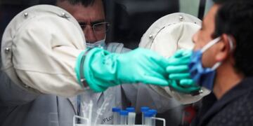 Doctor Gustavo Flores takes a swab sample from an ambulance with a booth, as part of a demonstration to test for the coronavirus disease (COVID-19), as part of the detectAR (detect) plan, in Beccar, on the outskirts of Buenos Aires, Argentina June 17, 2020\u002E REUTERS/Agustin Marcarian    hisopado pcr   casos del dia