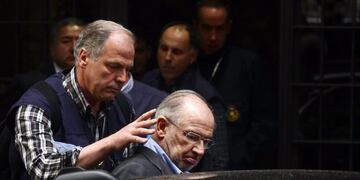 (FILES) A file picture taken on April 16, 2015 shows a member of the police (L) assisting former IMF head and ex economy minister with Spain's ruling conservative party Rodrigo Rato (C) into a vehicle outside his home in Madrid. nEx-IMF chief Rato was han