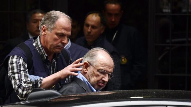 (FILES) A file picture taken on April 16, 2015 shows a member of the police (L) assisting former IMF head and ex economy minister with Spain's ruling conservative party Rodrigo Rato (C) into a vehicle outside his home in Madrid. nEx-IMF chief Rato was han