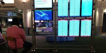 El hombre jugando a la PlayStation en un monitor donde se muestran los vuelos\u002E (Twitter)