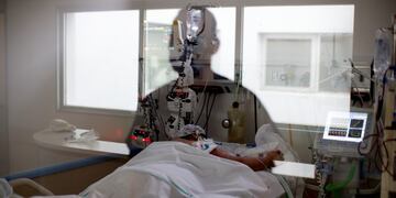 A nurse is reflected on a window at a COVID-19 ward where a patient lies in a hospital's intensive care unit in Buenos Aires, Argentina, Tuesday, Sept\u002E 15, 2020\u002E (AP Photo/Natacha Pisarenko) TERAPIA INTENSIVA - CASOS DEL DIA