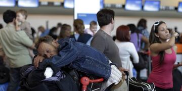hombre descansa sobre su equipaje mientras aguarda para registrarse ante el mostrador de Aerolu00edneas Argentinas en el aeropuerto internacional de Ezeiza, en las afueras de Buenos Aires, el lunes 14 de noviembre de 2011. Los vuelos internacionales de la compau00f1u00eda argentina comenzaron el lunes a operar con normalidad tras los trastornos generados por una huelga de personal tu00e9cnico. (AP foto/Natacha Pisarenko) aeropuerto de ezeiza  demoras en aeropuerto conflicto gremial pasajeros demoras problemas vuelos vuelos de aerolineas reprogramacion