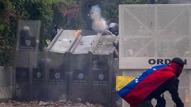 -FOTODELDIA- CAR19. CARACAS (VENEZUELA), 04/05/2017.- Manifestantes se enfrentan con policu00edas antimotines hoy, jueves 4 de mayo de 2017, en Caracas (Venezuela). Los cuerpos de seguridad dispersaron con gases lacrimu00f3genos la manifestaciu00f3n de estudiantes que se concentru00f3 en la Universidad Central de Venezuela (UCV) para intentar trasladarse hasta la sede del Ministerio de Interior y Justicia, ubicada en el centro de Caracas. EFE/Miguel Gutiu00e9rrez