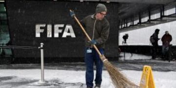 A man sweeps snow next to the FIFA logo on the occasion the FIFA Council meeting at the Home of FIFA in Zurich, Switzerland, Tuesday, January 10. FIFA will expand the World Cup to 48 teams, adding 16 extra nations to the 2026 tournament which is likely to