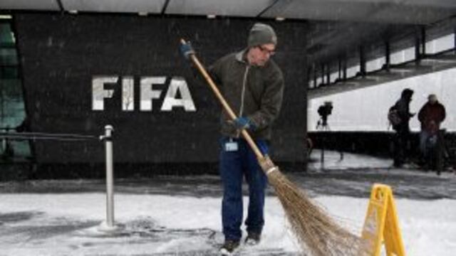 A man sweeps snow next to the FIFA logo on the occasion the FIFA Council meeting at the Home of FIFA in Zurich, Switzerland, Tuesday, January 10. FIFA will expand the World Cup to 48 teams, adding 16 extra nations to the 2026 tournament which is likely to
