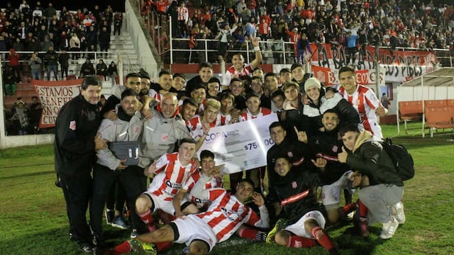 Los jugadores sostienen el cheque con los 750.000 pesos y la hinchada celebra el pase a semifinales