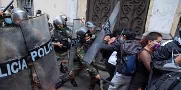Supporters of Peru's former President Martin Vizcarra are stopped by police from marching to Congress where lawmakers voted the previous night to remove Vizcarra from office, in Lima, Peru, Tuesday, Nov\u002E 10, 2020\u002E Congress voted to oust Vizcarra over his handling of the new coronavirus pandemic and unproven allegations of corruption years ago\u002E (AP Photo/Rodrigo Abd)