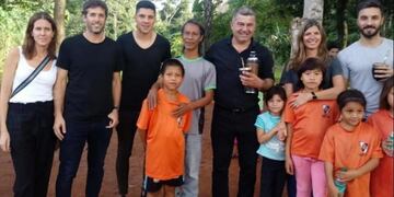 Nacho Scocco y Enzo Pérez con chicos de la aldea guaraní de Iguazú donde River financió un polideportivo\u002E (El Territorio)