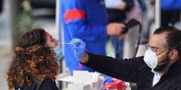 A medical worker takes a nasal swab sample from a student to test for COVID-19 at the Brooklyn Health Medical Alliance urgent care pop up testing site as infection rates spike on October 8, 2020 in New York City\u002E - New York's governor announced earlier in the week tough new restrictions in several areas recording high infection rates to try to ward off a second coronavirus wave\u002E (Photo by Angela Weiss / AFP)