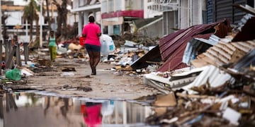 A woman walks on a street in Marigot, on September 11, 2017 on the French Caribbean island of Saint-Martin after it was hit by Hurricane Irma\u002E / AFP PHOTO / Martin BUREAU