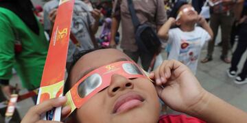 In this Thursday, Dec\u002E 26, 2019, file photo, a child looks up at the sun wearing protective glasses to watch a solar eclipse from Jakarta, Indonesia\u002E (AP Photo/Tatan Syuflana, File)