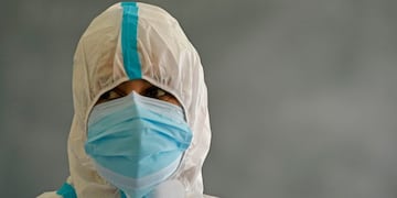 A medical worker looks on while collecting a swab sample from a male staff of Burnhall school inside a classroom for a Rapid Antigen Test (RAT) for the Covid-19 coronavirus, in Srinagar on October 5, 2020\u002E (Photo by TAUSEEF MUSTAFA / AFP)
