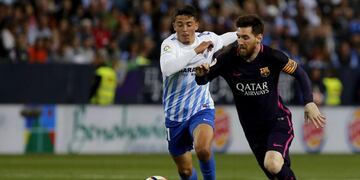 GRA498. Mu00c1LAGA. 08/04/2017. El delantero argentino del Barcelona Lionel Messi (d) lucha por el balu00f3n ante el centrocampista del Mu00e1laga Pablo Fornals (i), durante el partido de la jornada trigu00e9sima primera de Liga en Primera Divisiu00f3n que se juega esta noch