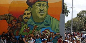 AME2209\u002E CARACAS (VENEZUELA), 12/02/2019\u002E- Un grupo de jóvenes posa junto a un mural del expresidente Hugo Chávez, durante una marcha en apoyo al gobierno del presidente de Venezuela, Nicolás Maduro, este martes, en Caracas (Venezuela)\u002E El presidente Nicolás Maduro, en el poder desde 2013, recibirá en el centro de Caracas a simpatizantes que marcharán para denunciar un presunto intento de golpe de Estado a su gestión y pedir que se respete la soberanía venezolana, que consideran amenazada por factores \