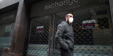 A man wearing a face mask as a protective measure against the coronavirus disease (COVID-19) walks past a closed currency exchange shop, in downtown Buenos Aires, Argentina May 22, 2020\u002E REUTERS/Agustin Marcarian