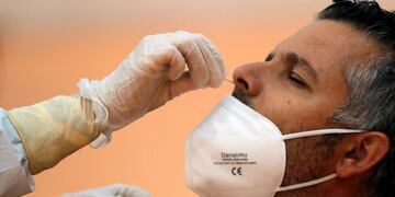 FILE PHOTO: A healthcare worker takes a swab sample from a man to be tested for the coronavirus disease (COVID-19) during a massive test in the small Andalusian village of Arriate, Spain November 7, 2020\u002E REUTERS/Jon Nazca/File Photo