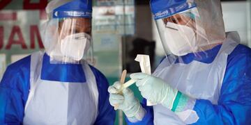 A clinic doctor checks sample for coronavirus testing after they collected it from a man on the outskirt of Kuala Lumpur, Malaysia, Tuesday, Oct\u002E 6, 2020\u002E The health ministry has warned that Malaysia is facing a new wave of virus cases as the outbreak has widened in recent days\u002E New clusters have sprung up in many states amid increased travel to eastern Sabah state, a hotspot zone, for a state election last month\u002E (AP Photo/Vincent Thian)