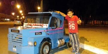 El hijo de Oscar posa orgulloso con el camión a escala fabricado por su padre\u002E