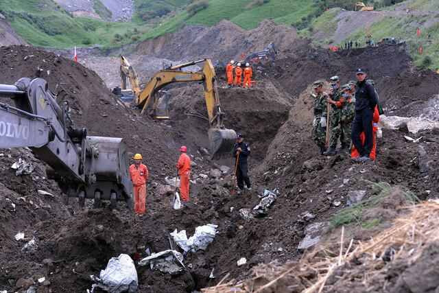 Los equipos de rescate buscan víctimas de un deslizamiento de tierra que enterró una mina de mineral de hierro en Xinyuan