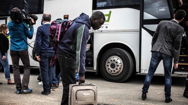 Migrants arrive by bus from the Calais Jungle, on October 24, 2016 at the Montlaville castle in Chardonnay.nFrench authorities began on October 24, 2016 moving thousands of people out of the notorious Calais Jungle camp before demolishing the camp that has served as a launchpad for attempts to sneak into Britain. Migrants lugging meagre belongings boarded buses taking them away from Calais'