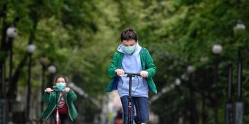 VALLADOLID, 26/04/2020\u002E- Dos niños juegan con sus patinetes en un parque de la ciudad de Valladolid durante el primer día en el que los menores de 14 años salen a la calle, acompañados de un adulto y durante una hora, después de más de cuarenta días de confinamiento debido al estado de alarma decretado para combatir la pandemia del coronavirus\u002E EFE/Nacho Gallego