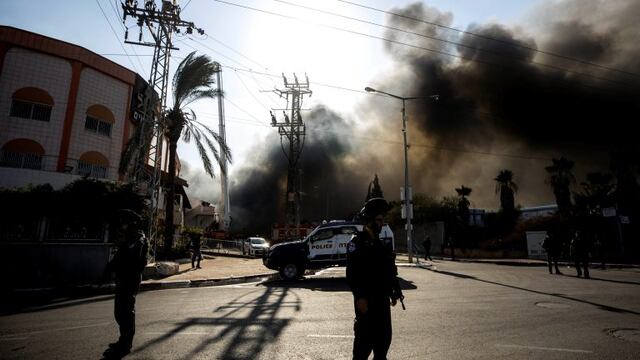 Police stands guard after a factory hit by a rocket caught fire in Sderot, southern Israel , Israel, Tuesday, Nov\u002E 12m 2019\u002E Israel has killed a senior Islamic Jihad commander in Gaza in a rare targeted killing that threatened to unleash a fierce round of cross-border violence with Palestinian militants\u002E (AP Photo/Tsafrir Abayov)