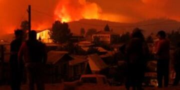 Habitantes de Santa Olga, Constituciu00f3n (Chile), observan las llamas de los incendios forestales el 25/01/2017. foto: Victor Perez/Agencia Uno/dpa