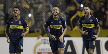 Argentina's Boca Juniors forward Dario Benedetto (C) celebrates next to teammates forward Carlos Tevez (L) and Uruguayan midfielder Nahitan Nandez after shooting a penalty kick to score his team's second goal, against Bolivia's Wilstermann during the Copa Libertadores 2019 group G football match at the \