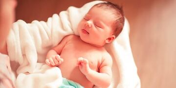 Tierna imagen de un bebé recién nacido cuando le quita el barbijo a su médico (Web)