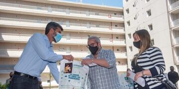 El jefe comunal Ulpiano Suárez entrega las llaves de uno de los departamentos a una de las familias adjudicadas