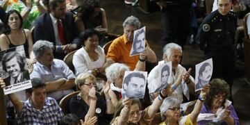 Members of human rights organizations hold pictures of their loved ones as they sit in a courtroom during the final stage of the trial of 21 men charged with kidnapping, torture and murder in the notorious clandestine detention centre known as La Cacha, in La Plata October 24, 2014. The centre located in the city of La Plata, is believed to have been used between 1976 and 1978. It is estimated that at least 200 people were held there, many of whom were tortured and killed. REUTERS/Enrique Marcarian (ARGENTINA - Tags: CRIME LAW CIVIL UNREST SOCIETY) la plata buenos aires juicio oral delitos dictadura centro clandestino la cacha juicio acusados secuestros en la ultima dictadura militar miembros de las organizaciones de derechos humanos sostienen fotografu00edas de sus seres queridos