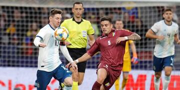 Leo Messi lucha con Júnior Moreno, de Venezuela, durante un amistoso\u002E (Foto: Juan Carlos Hidalgo/EFE)