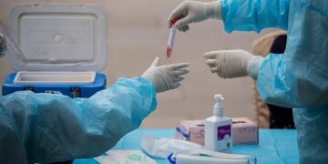 Medical workers wearing full protective gear prepare to take swab samples from a journalist (not pictured) to test for the COVID-19 coronavirus, nine hours before the closing ceremony of the National People's Congress (NPC) at the Diaoyutai hotel in Beijing on May 28, 2020\u002E - All journalists accredited to cover the National People's Congress events have to pass the COVID-19 test\u002E (Photo by NICOLAS ASFOURI / AFP)