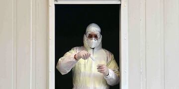 A Covid-19 tester holds a testing tube in a car testing station in Erkheim, southern Germany, on November 4, 2020, amid the new coronavirus COVID-19 pandemic\u002E (Photo by Christof STACHE / AFP)