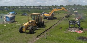 Grúas remueven las casillas que habían sido instalada por los ocupantes en el terreno de Guernica, desalojado este jueves por la Policía Bonaerense\u002E (Clarín)