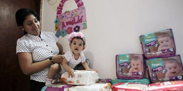 Yeslany Davila plays with her daughter on a pile of diapers she has managed to accumulate at her house in Maracaibo, Venezuela July 3, 2015\u002E Picture taken on July 3, 2015\u002E To match Feature VENEZUELA-MOTHERS/ REUTERS/Isaac Urrutia venezuela maracaibo  informe sobre la maternidad en maracaibo madre acumula pañales en su casa