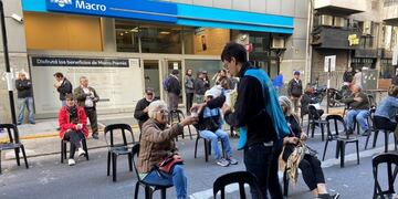 Sillas, té caliente y alcohol en gel para jubilados en las puertas de los bancos (@CaroLabayru)