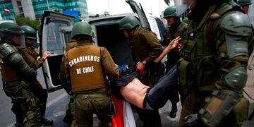 TOPSHOT - The police arrest a demonstrator during clashes between protesters and the police at Plaza de Maipu in Santiago, on October 19, 2019\u002E - Chile's president declared a state of emergency in Santiago Friday night and gave the military responsibility for security after a day of violent protests over an increase in the price of metro tickets\u002E (Photo by Pablo VERA / AFP)