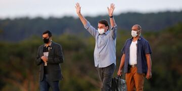 Brazil's President Jair Bolsonaro greets his supporters before a ceremony of lowering the national flag for the night, amid the coronavirus disease (COVID-19) outbreak, at the Alvorada Palace in Brasilia, Brazil, July 19, 2020\u002E REUTERS/Adriano Machado