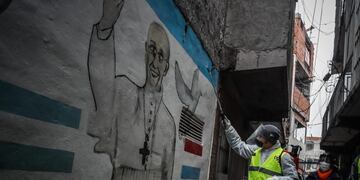 AME4732\u002E BUENOS AIRES (ARGENTINA), 05/06/2020\u002E- Un hombre desinfecta un mural con la imagen del papa Francisco como parte de la campaña de prevención contra la propagación del coronavirus este viernes en el barrio Padre Rodolfo Ricciardelli, anteriormente conocido como Villa 1-11-14, en la Ciudad de Buenos Aires (Argentina)\u002E EFE/Juan Ignacio Roncoroni