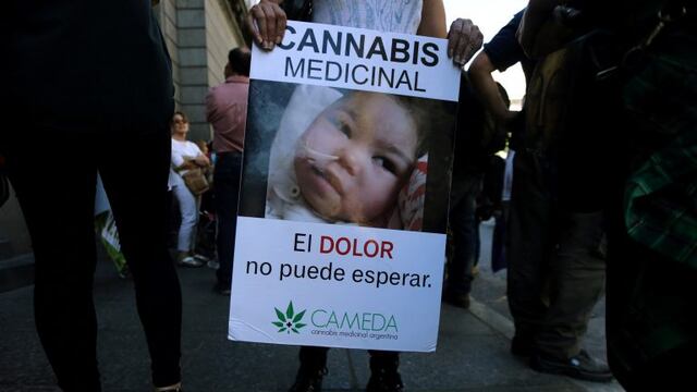A woman holds a sign as she waits outside the Congress for the Senate to pass a law to legalise the medical use of cannabis in Buenos Aires, Argentina, March 29, 2017. The sign shows a girl named Nayra, who suffers from refractory partial epilepsy and has