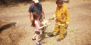 Emotivo gesto de una niña que le da pizza a bomberos voluntarios que trabajan en los incendios de Alpa Corral\u002E